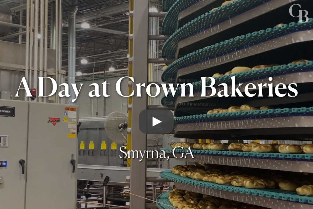 Baked croissants on a spiral conveyor belt.