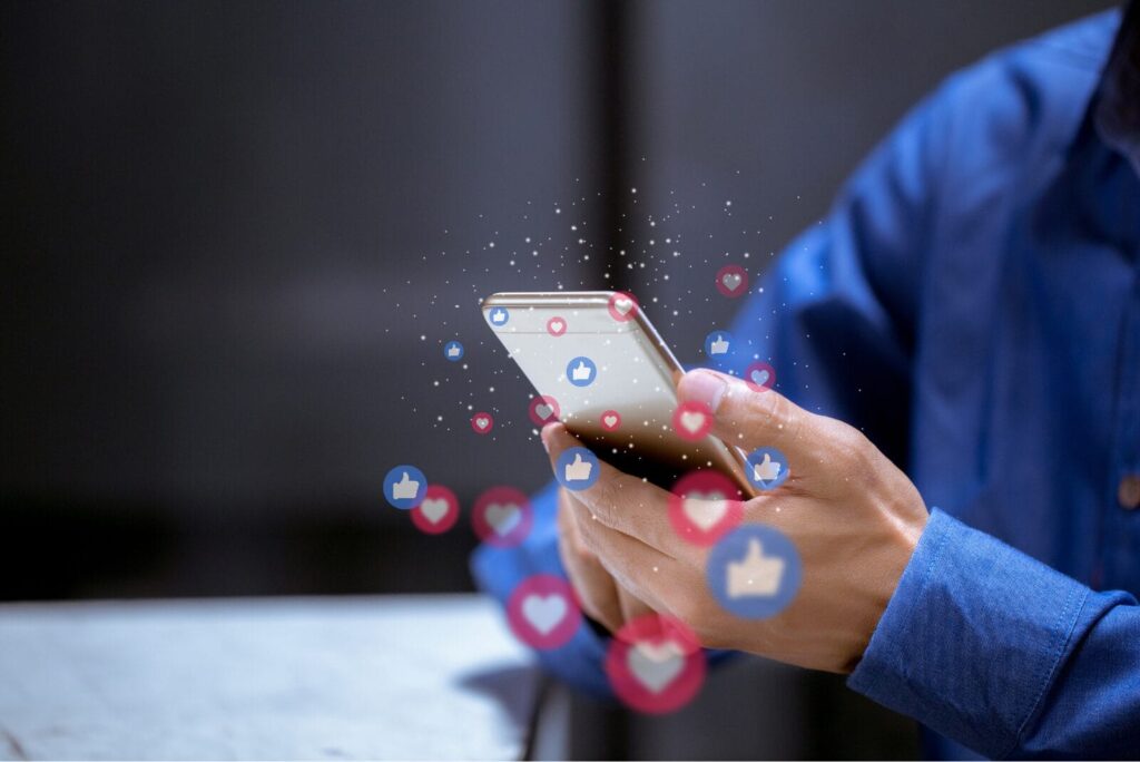 man holding phone with like and love symbols around