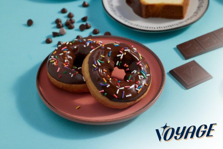 Chocolate donuts on plate next to Voyage Foods logo