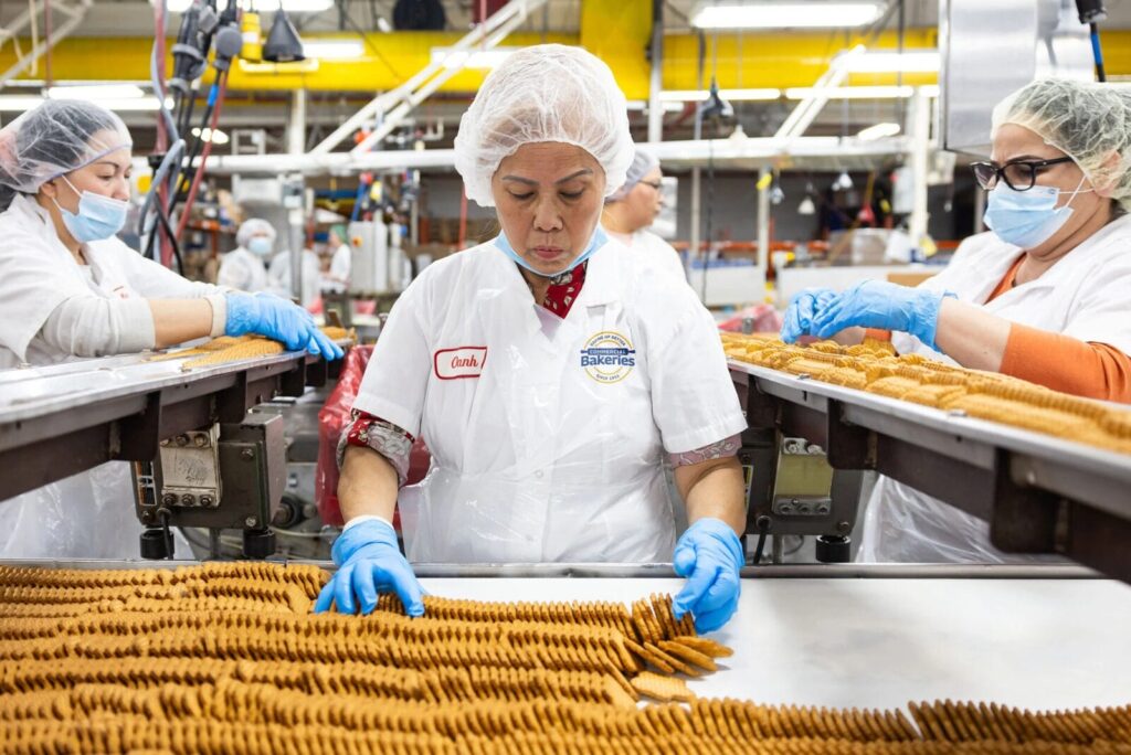 Baker in warehouse with bread products.