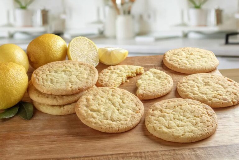 Plate of cookies next to lemons on cutting board.