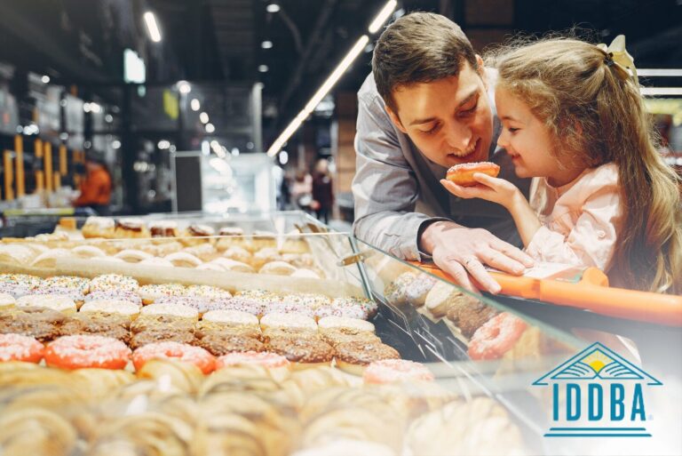 Man and young child looking at donut case