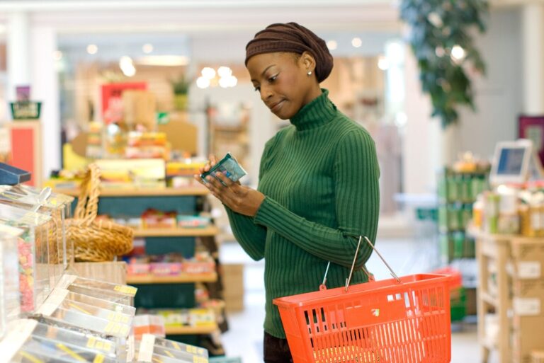 Woman reading product label at grocery store.