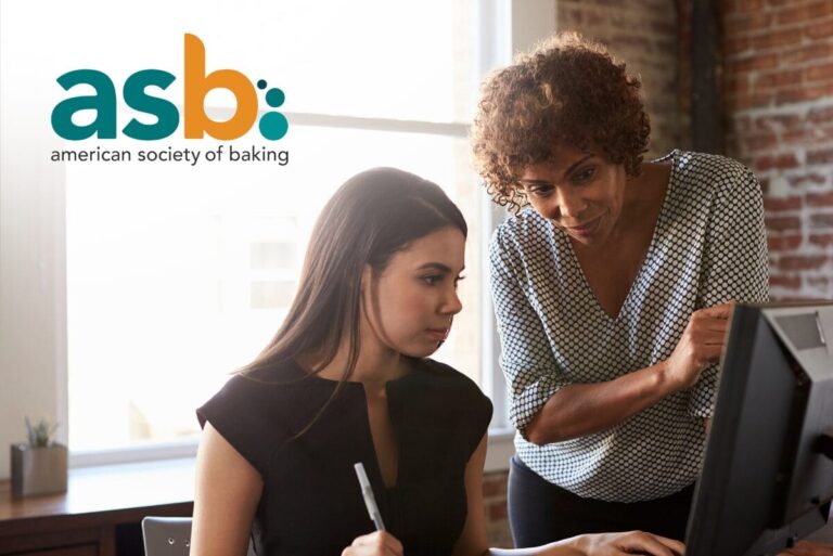 Two women looking at a computer and American Society of Baking logo in upper left corner