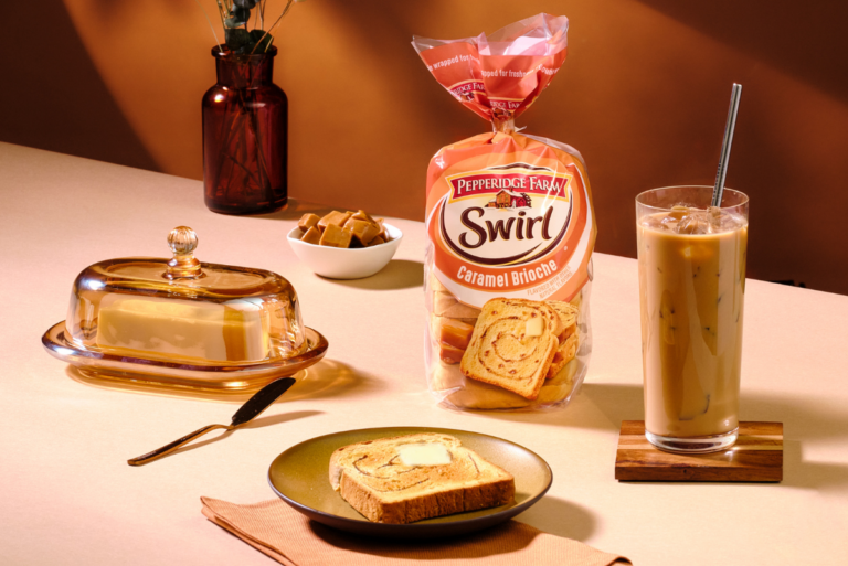 Bag of Pepperidge Farm Caramel Swirl Bread on table with iced coffee, toast and butter dish