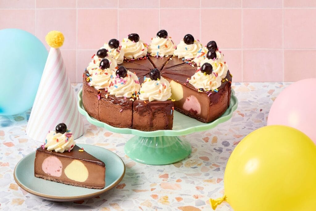 Eli's Cheesecake Cheesecake Sundae on green cake tray with party decorations