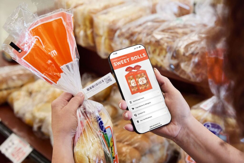 person holding bag of bread and scanning 2d code with phone for additional information