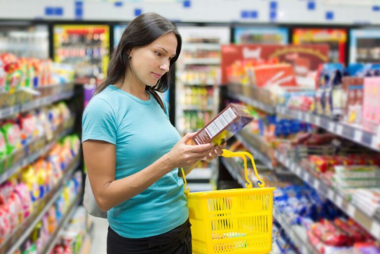A consumer looking at a product label while grocery shopping