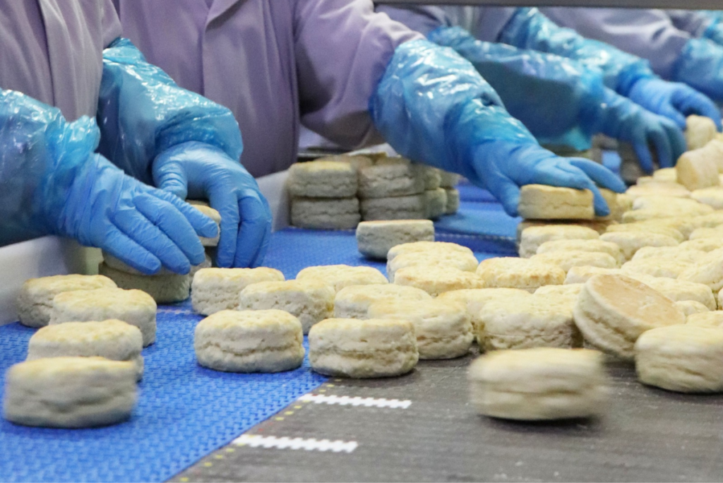 Lone Star Bakery employees placing biscuits on production line