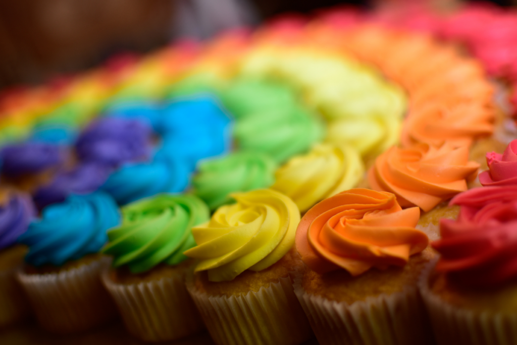 Rainbow cupcakes lined up in an arch