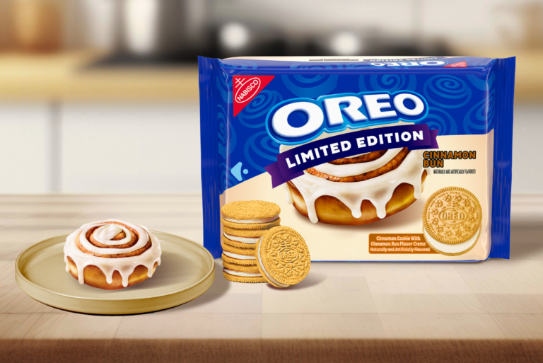 Lifestyle shot of a pack of OREO Cinnamon Bun Cookies next to a plate with a cinnamon bun