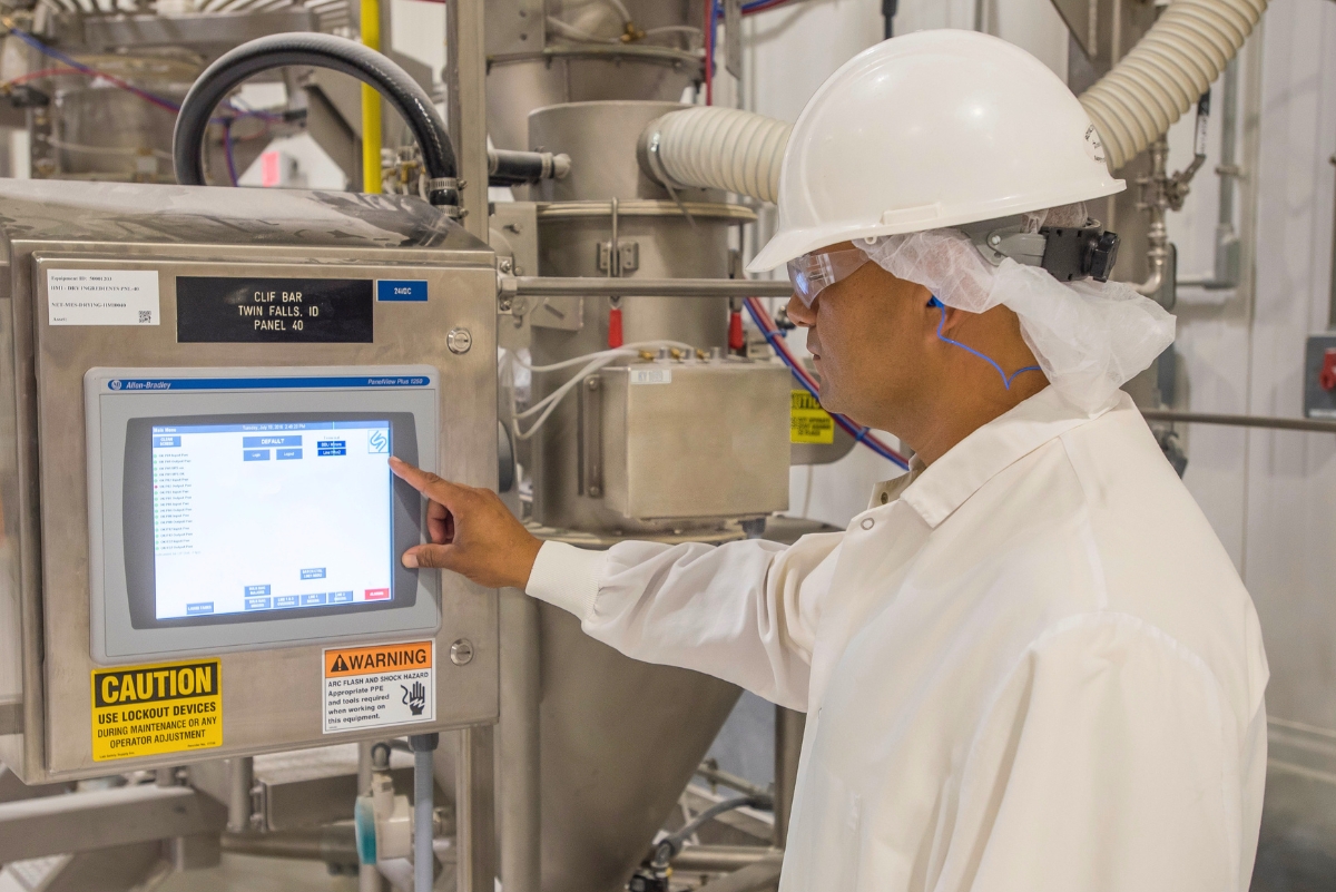 bakery worker interacting with a screen for automated equipment
