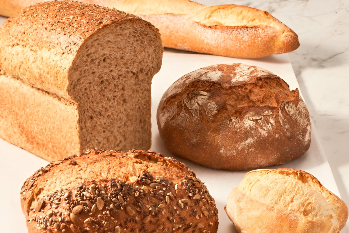 Variety of bread products, including a baguette, loaf and bun