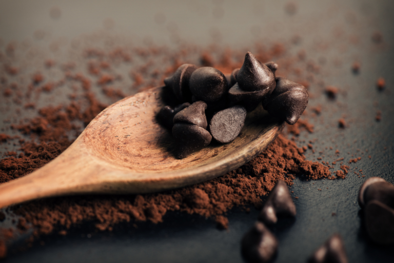 counter with wooden spoon covered in cocoa powder and chocolate chips