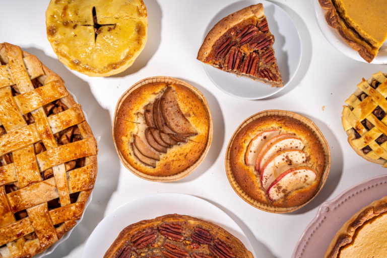 Assorted pie types and sizes plated on white background