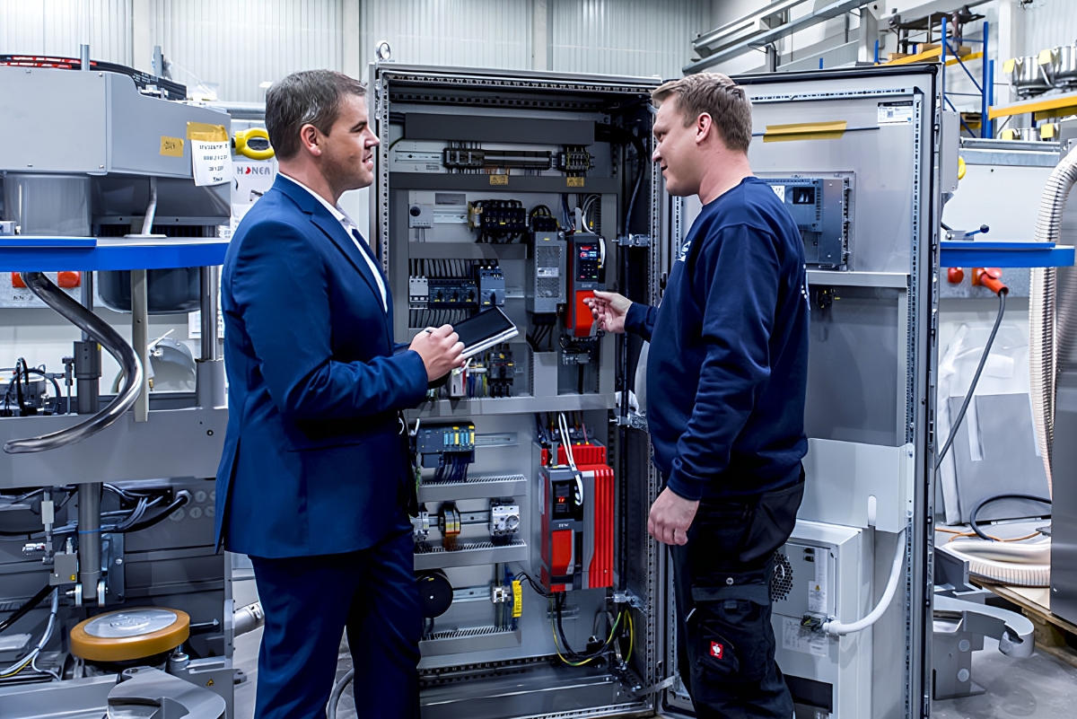 two men surveying a piece of bakery equipment